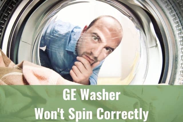 Bald guy looking inside the washing machine door window