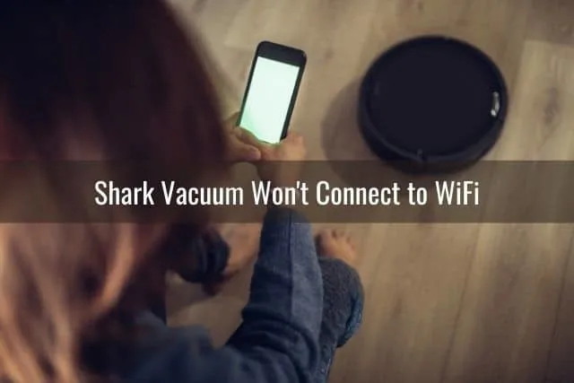 Person using a phone to configure robotic vacuum