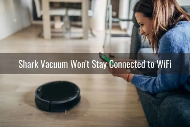 A woman using her phone app to see robotic vacuum settings