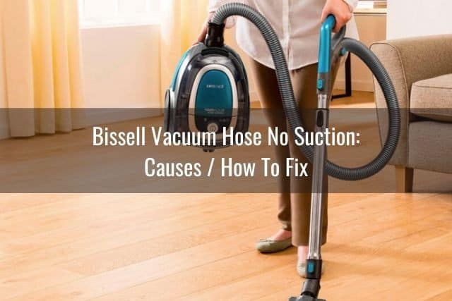 Woman holding a canister vacuum cleaning hardwood floor