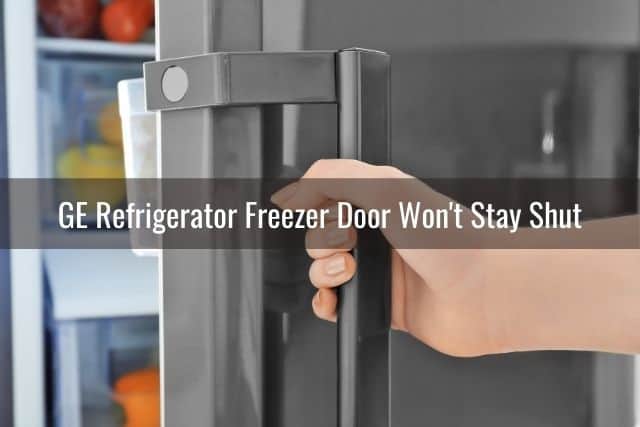 Hand on refrigerator door handle