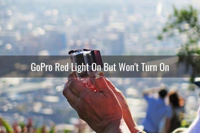 A person looking at the a GoPro camera screen with blurred city background