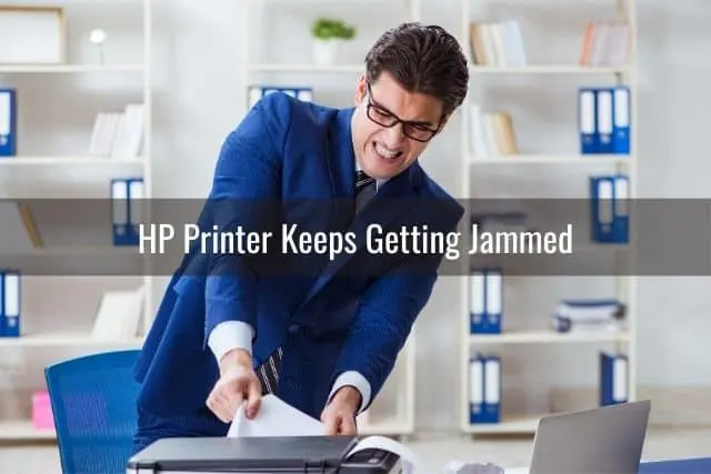 Businessman pulling paper out from printer