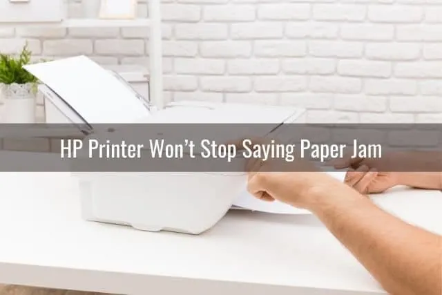 Hand removing paper from white printer