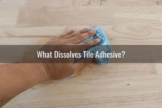 A hand with a towel cleaning the floor