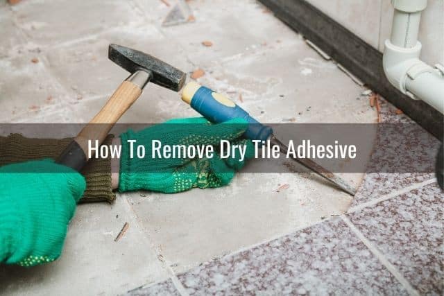 A hammer and chisel removing tile floor