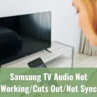 Woman looking at phone with TV in background
