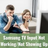 A couple looking annoyed while watching TV