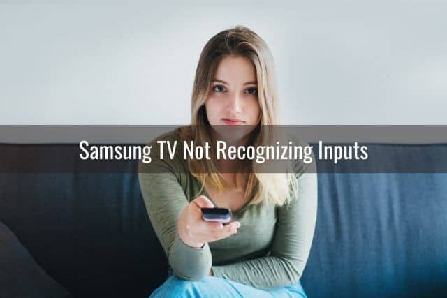 An annoyed looking girl with a TV remote in hand