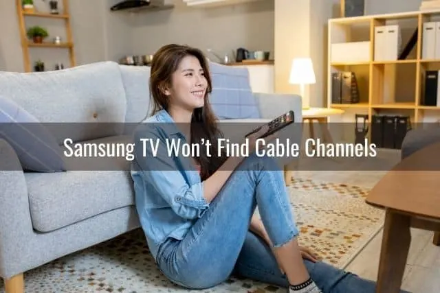 Woman sitting on ground with remote in hand watching TV