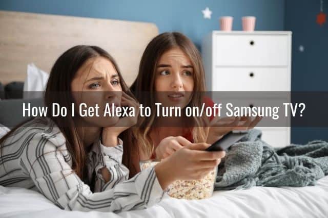 A couple of teenage girls lying on a bed frustrated with a TV remote control