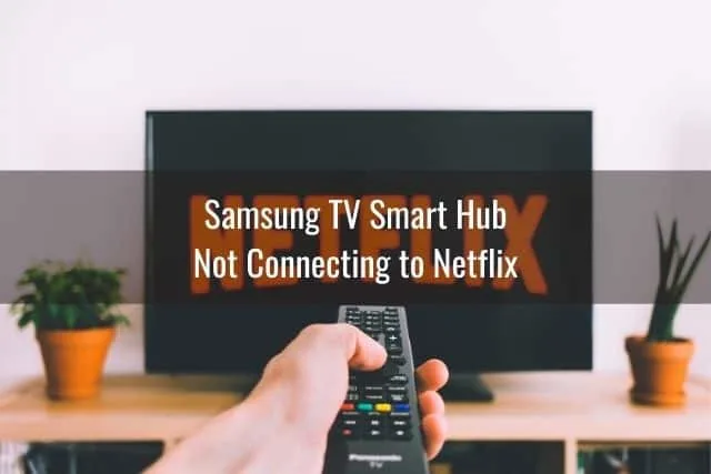 Hand holding remote that's pointed to the TV with Netflix on