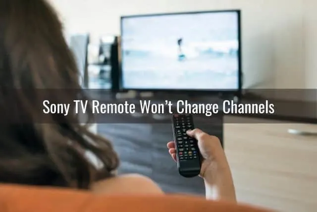 Female holding remote and pointing it at the TV