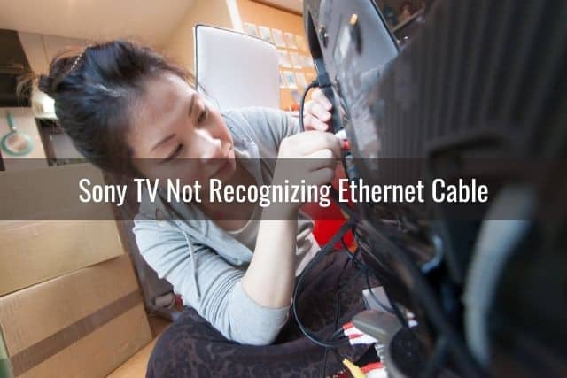 Female that is plugging back cables in the back of a TV