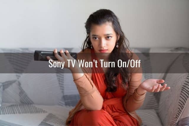 Confused woman sitting on sofa with TV remote in hand