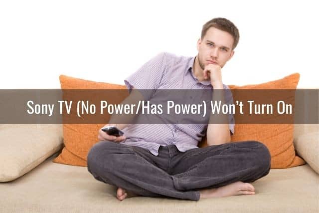 Guy sitting on sofa holding TV remote