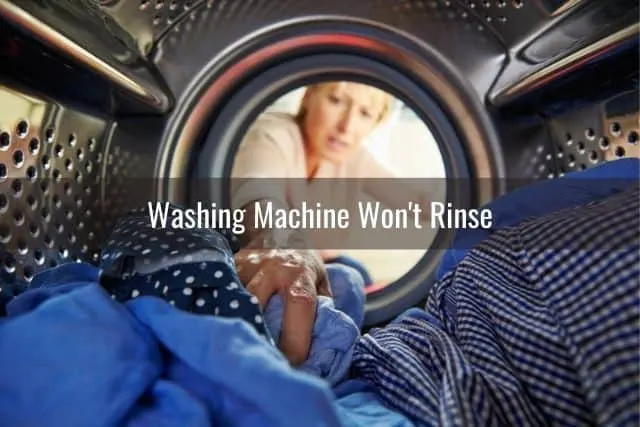 Woman reaching into a washing machine to pull out clothes