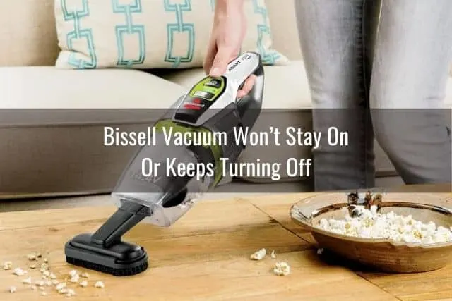Handheld vacuum picking up popcorn on the hardwood floor