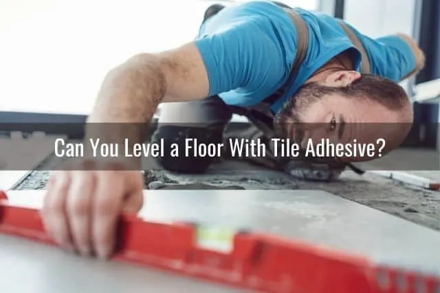 Man using a level to install tile floor