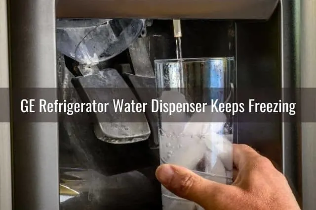 Hand holding cup under refrigerator water/ice dispenser