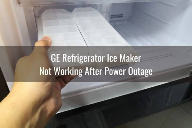 Hand removing ice tray from refrigerator freezer