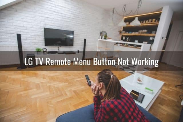 Female having trouble turning TV on with remote