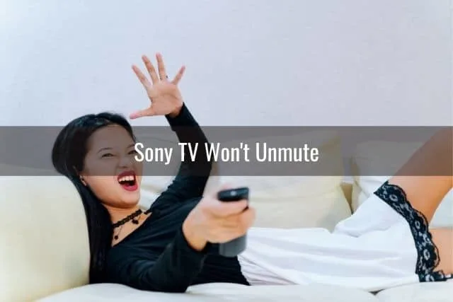 Young woman angry with hand in the air while watching TV