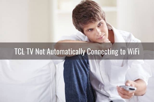 Male sitting on sofa using TV remote