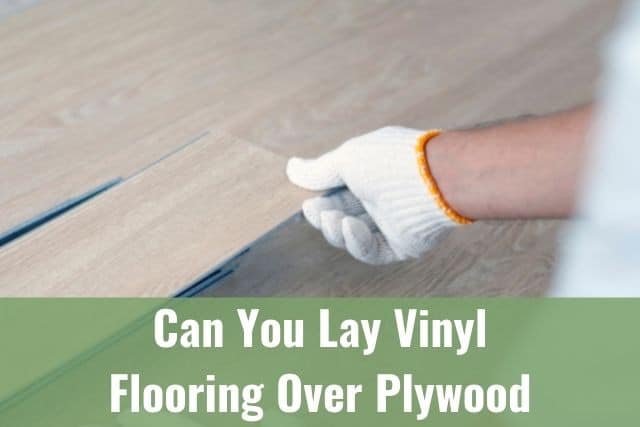 Gloved hand laying down vinyl flooring