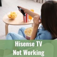Female using remote and watching TV while eating popcorn