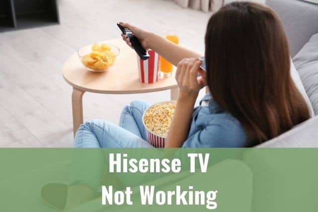 Female using remote and watching TV while eating popcorn