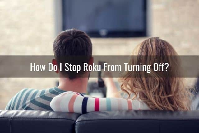 Two people sitting on sofa waiting for TV to turn on