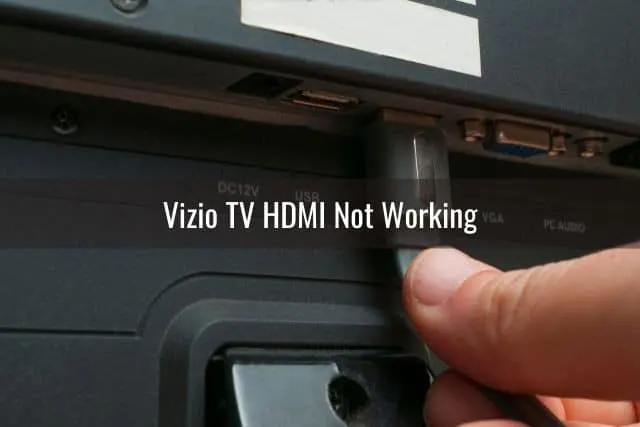 Hand pushing HDMI cable into back of TV port