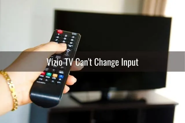 Person holding remote and pointing to TV that is turned off