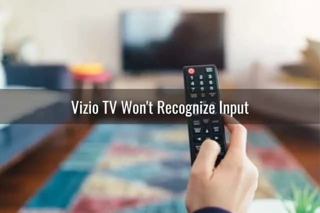 Hand holding remote using it to turn TV on