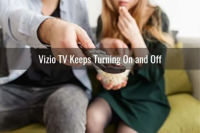 White male and female turning on TV and eating popcorn