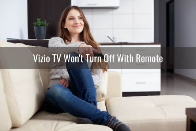 Female sitting on sofa using remote to change TV channels