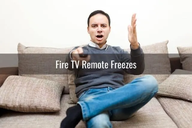Angry male sitting on sofa with TV remote in hand