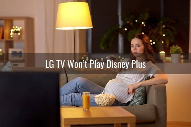 Pregnant female lounging on sofa eating popcorn while watching TV