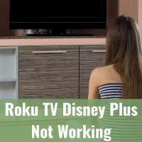 Female teenager sitting on living room floor looking at black TV screen