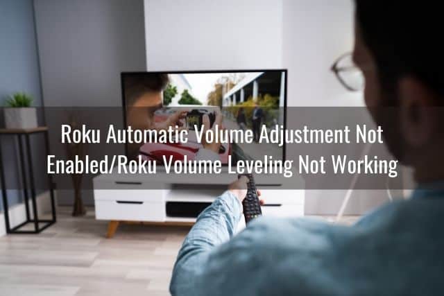Male adjusting TV volume with remote