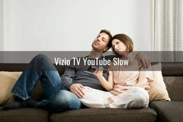 Couple sitting on sofa waiting for TV to load