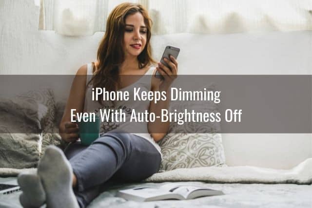 Female using iPhone while sitting on bed
