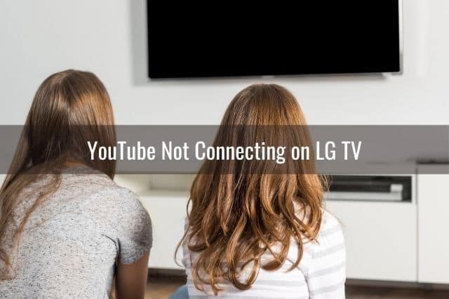 Two young females sitting on living room floor watching TV