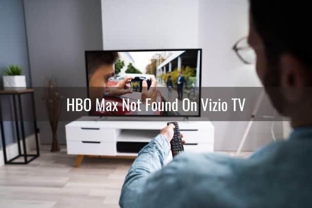 Male using remote to adjust volume on TV