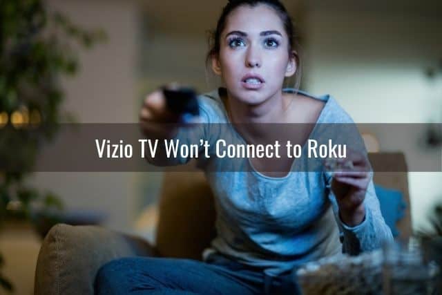 Female focused and using remote to turn up TV volume