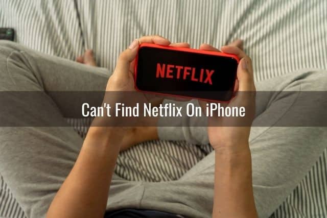 Person in pajamas sitting in bed watching Netflix on phone
