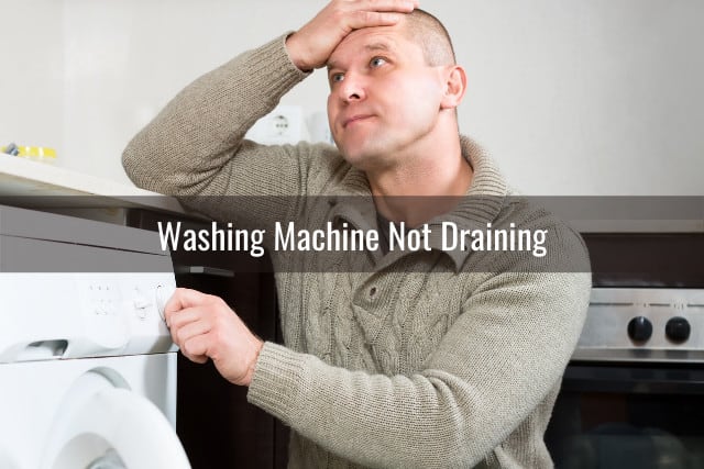 Frustrated man while behind the washing machine