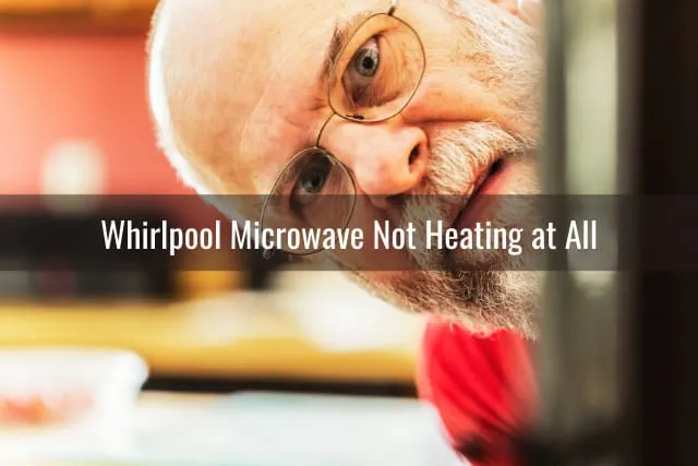 Old man checking the microwave
