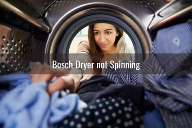 Woman pulling clothes out of dryer machine